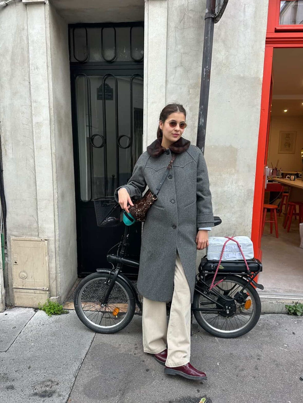 person standing beside a bicycle in front of a door