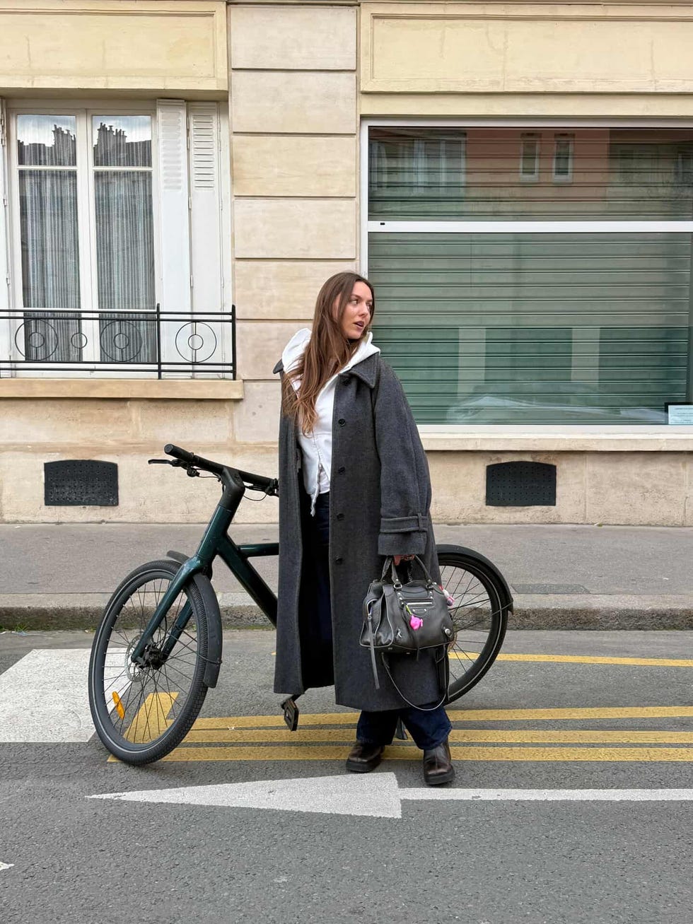person standing beside a bicycle on a street