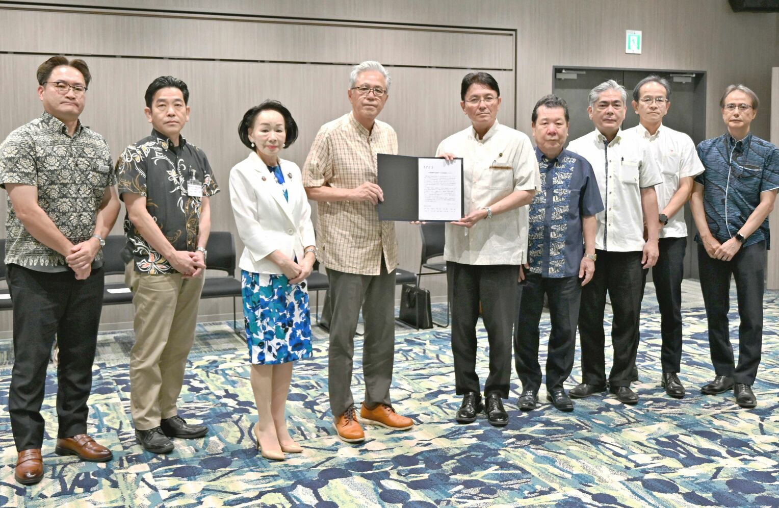 経済界有志から2期目を目指し、立候補するよう要請書を受け取る知念覚那覇市長(右から5人目)=18日、那覇市内