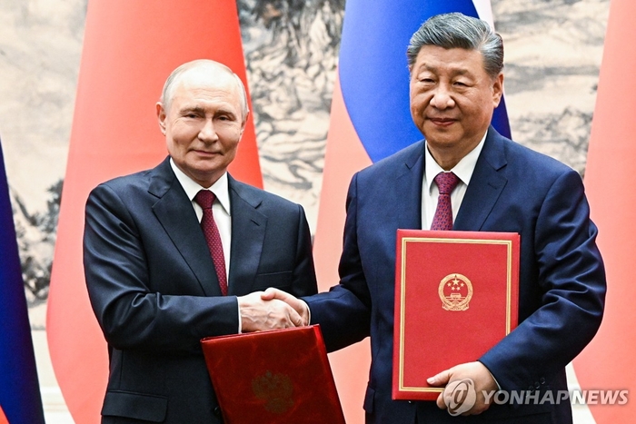 ロシアのプーチン大統領（左）と中国の習近平国家主席と20日、中国北京の人民大会堂で会談し、首脳会談を行った後、記念撮影をしている。 タス連合ニュース