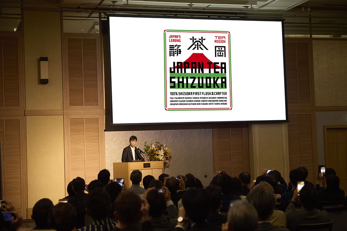プロジェクトの過程やロゴマークのデザインの意図を説明する佐藤氏。