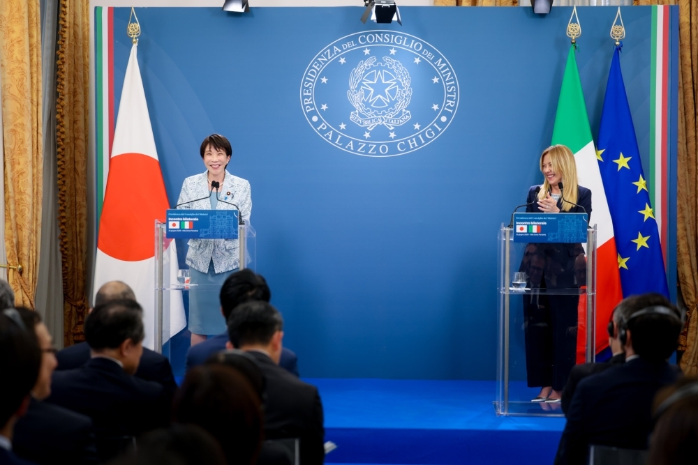 日本国旗とイタリア国旗・EU旗を背に、それぞれの演台に立ち笑顔で共同記者発表に臨む高市総理大臣とメローニ首相