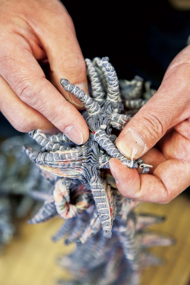 hands manipulating a textile object resembling coral　桐生絞