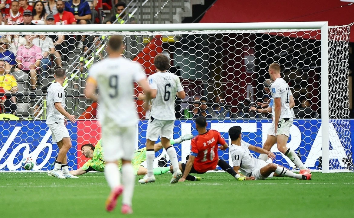 サラーはニュージーランドの選手たちに囲まれながらシュートを決め、ゴールを決めた。 Salah dứt điểm thành bàn giữa vòng vây của các cầu thủ New Zealand.