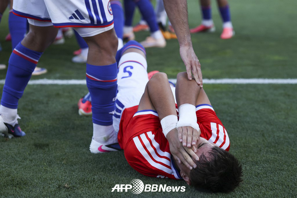 7日（韓国時間）、ポルトガル·オエイラスのエスタジウ·ナシオナルで行われたポルトガルとチリの親善試合の途中、ハファエル·レアンに殴られて倒れ、苦痛を訴えているチリのイワン·ローマン。 /AFPBBNews=ニュース1