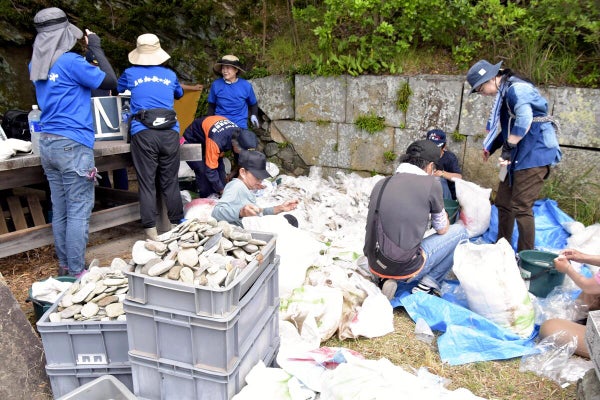 石室へ戻すため、経石をバケツやコンテナへ移す参加者