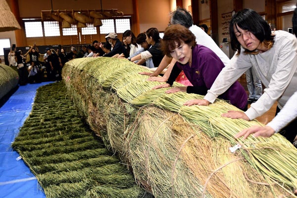 しめ縄の菰掛け作業に取り組む参加者ら（島根県飯南町で）