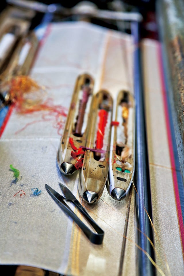 weaving tools and threads on a fabric surface