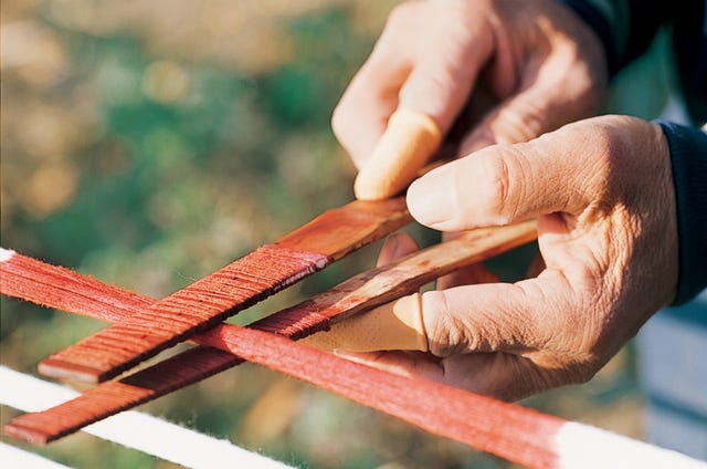 hands holding wooden sticks used for a traditional activity