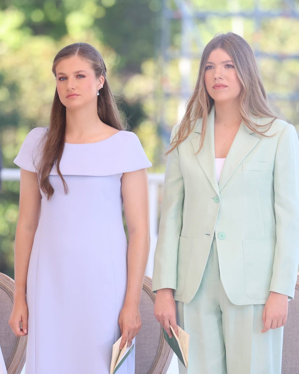 two women standing side by side dressed formally two women standing side by side dressed formally