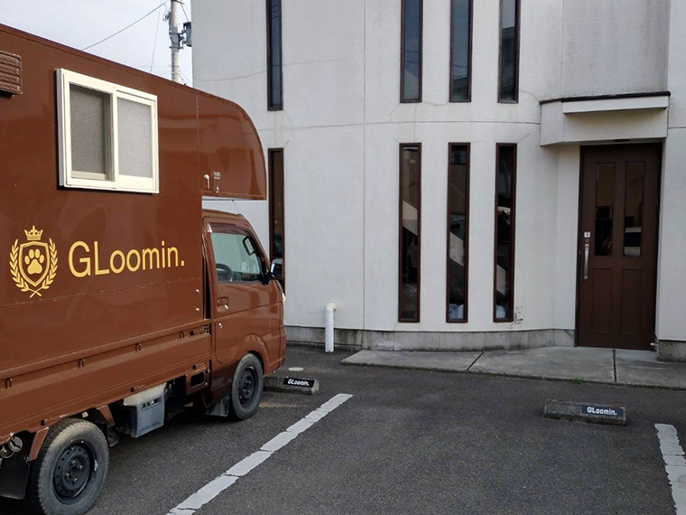 2階建ての店の外観と移動式ペットサロンのトリミングカー