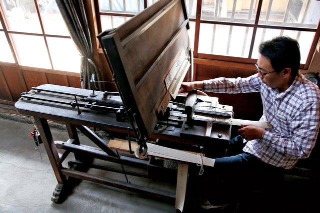 a person operating a traditional printing machine