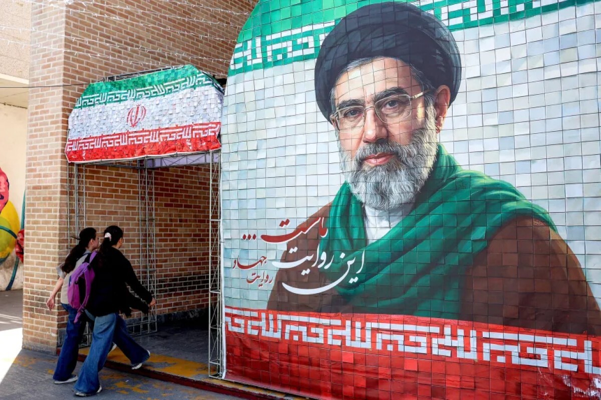イランの現最高指導者モジタバ・ハメネイ師の肖像の前を通り過ぎる女性たち＝5月6日/AFP/Getty Images