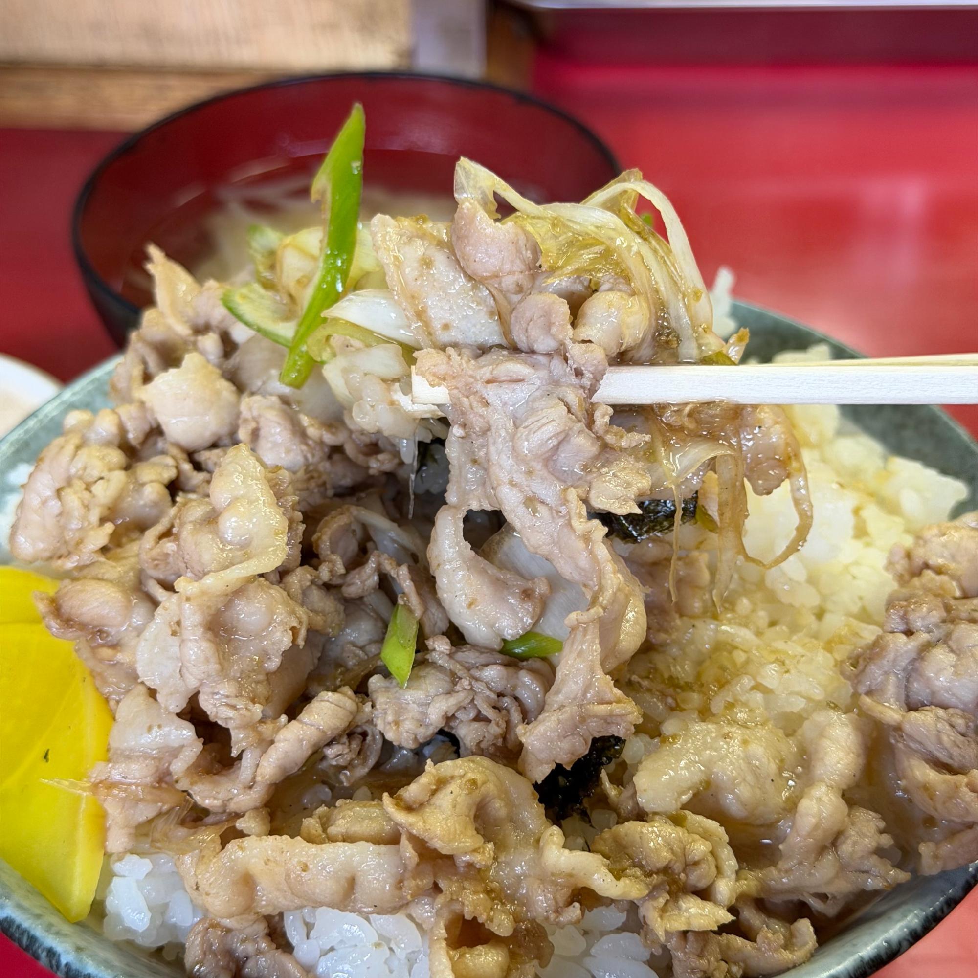 傍らに沢庵が2枚添えられた美しい丼から、まずは主役の豚バラ肉を白米とともに豪快に口へ掻っ込みます。