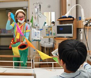 カラフルな布を使ったパフォーマンスをするホスピタル・クラウンのブロッサムさん＝5月26日、青森市の県立中央病院