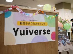 壁に「福島市多文化共生センター Yuiverse」のポスターが貼られている写真
