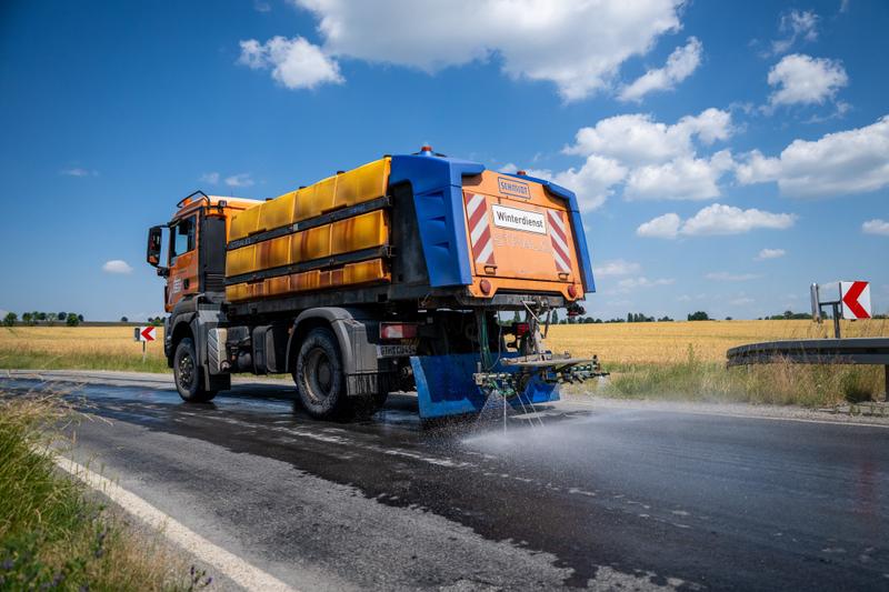 A winter maintenance vehicle sprays water on roads in Germany.