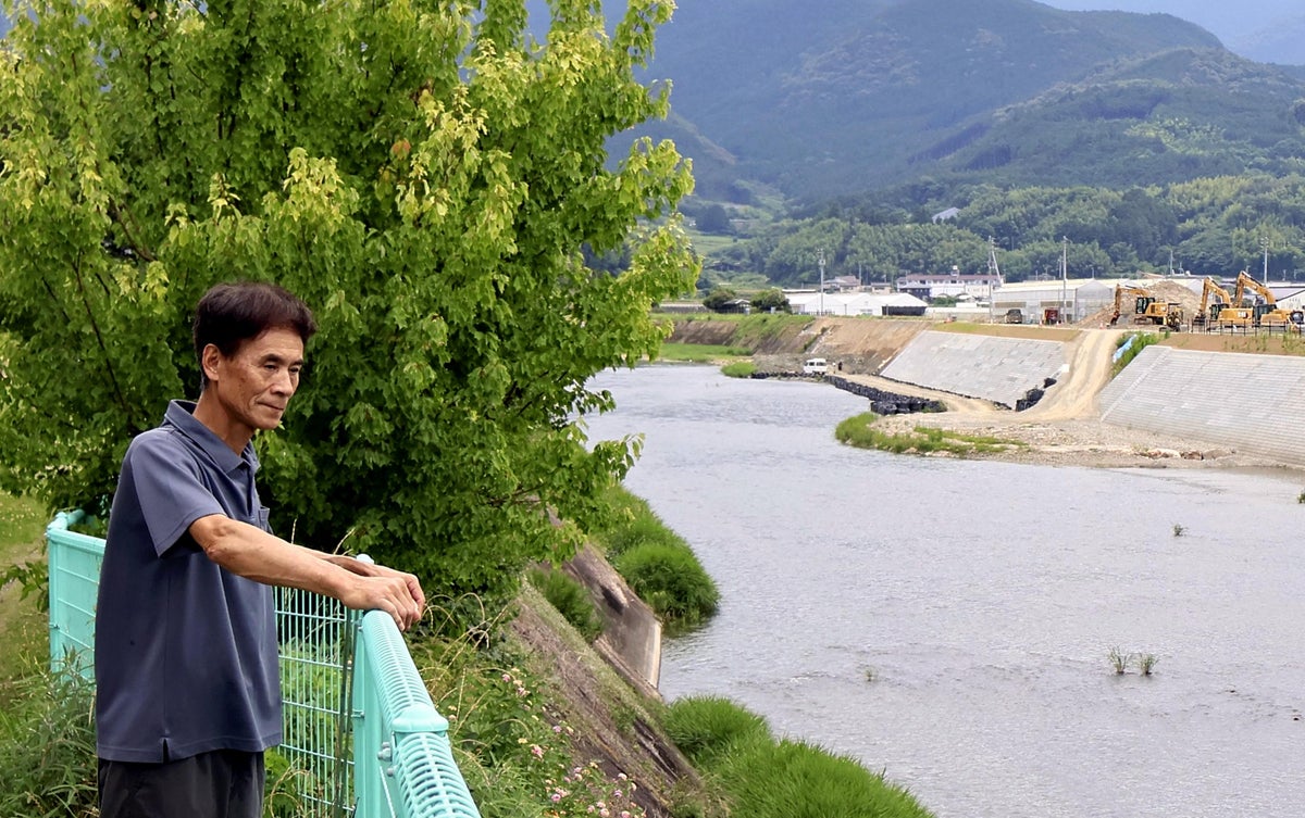 畳店前の肱川を眺める小玉さん（愛媛県西予市野村町で）