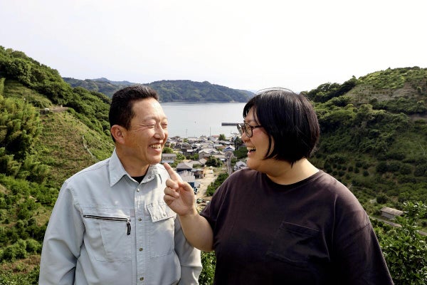 再生したミカン畑で笑顔を見せる赤松さん（左）と妻の甫美さん（６月、愛媛県宇和島市で）＝氷見優衣撮影