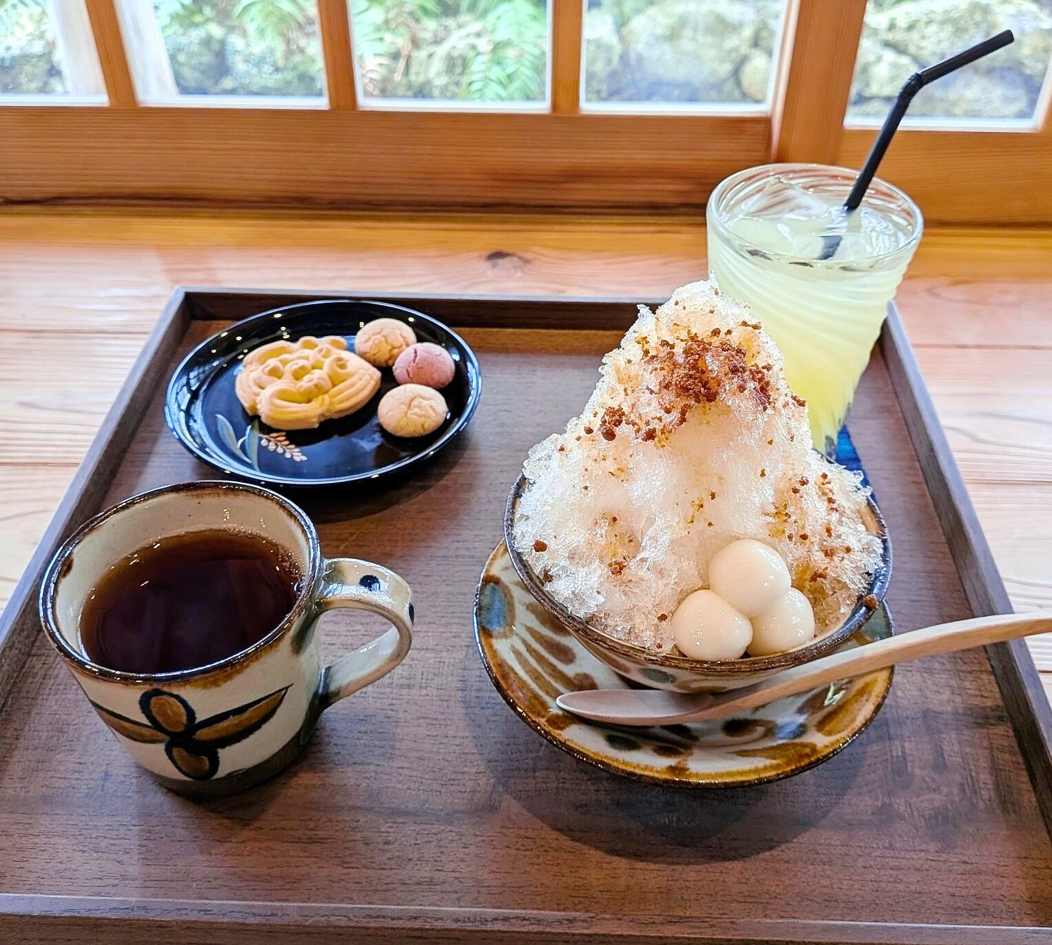 <div class="caption">大粒の金時豆に氷をのせた人気の「沖縄ぜんざい」(右手前)と、華やかな花ぼうるとチンスコウの「王朝焼き菓子」(左奥)。飲み物とセットでそれぞれ1300円と1200円。</div>