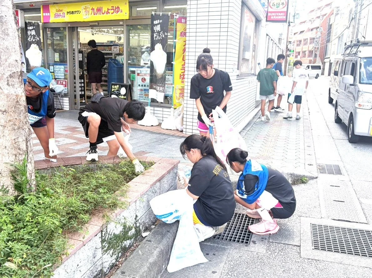 那覇STAGEで歩道脇のごみを拾う参加者たち