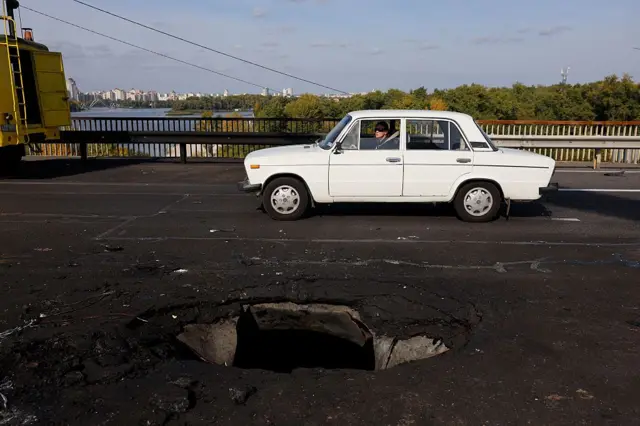 片側の車線に大きな穴が開いている。そのそばを白い乗用車が走っている